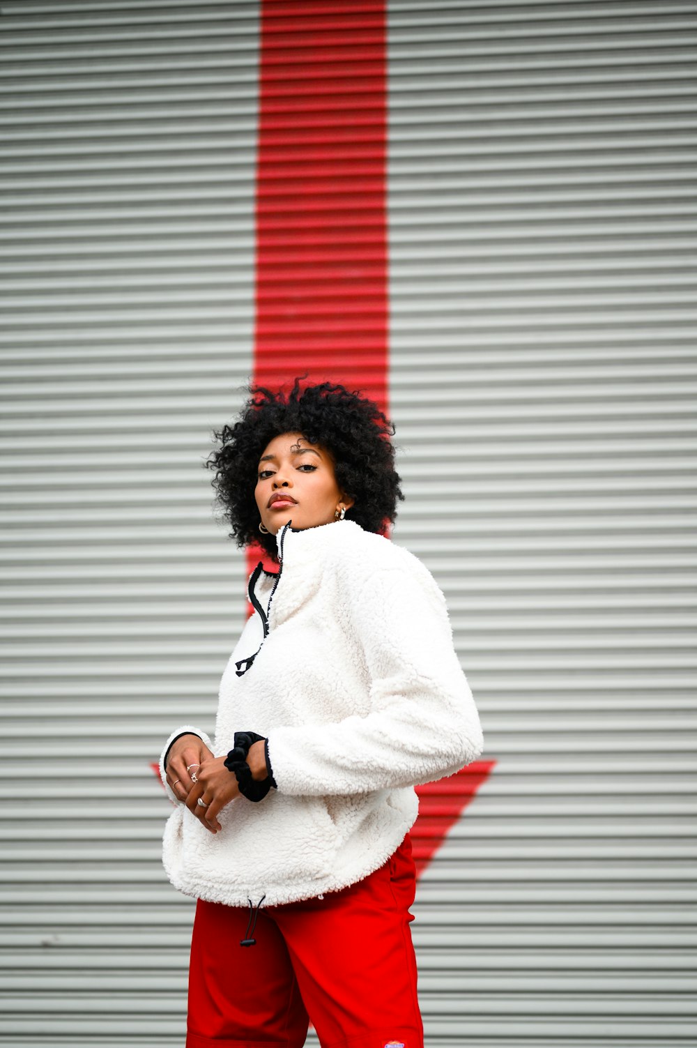 woman in white coat standing beside white wall