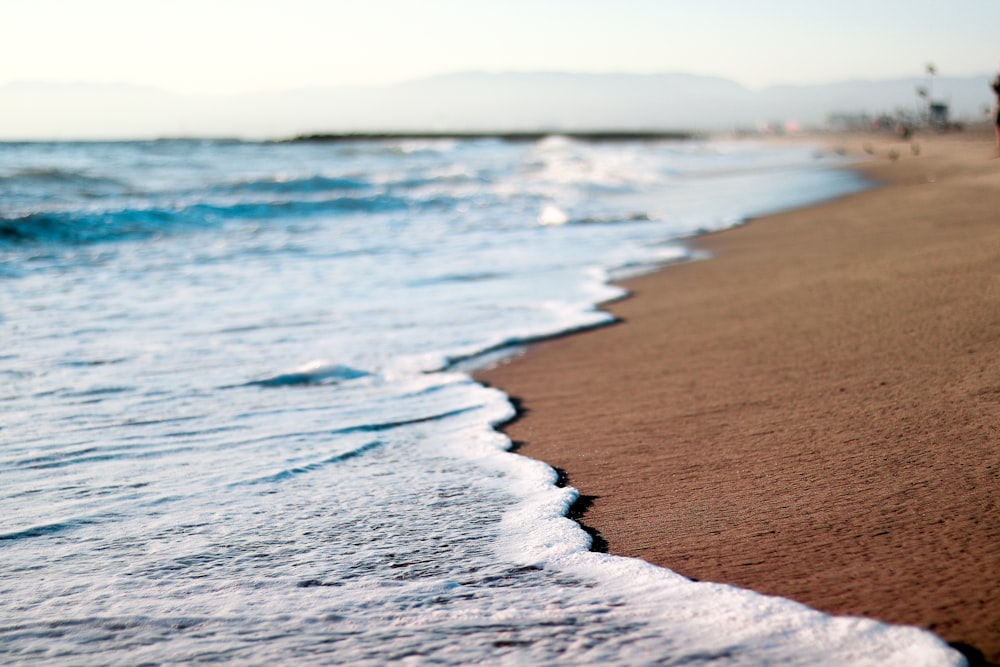 Onde del mare che si infrangono sulla riva durante il giorno