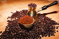 Close-up of freshly ground menengiç coffee beans with a traditional coffee pot.