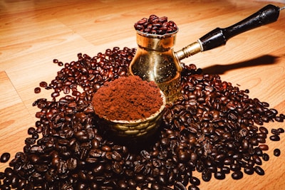 Close-up of freshly ground menengiç coffee beans with a traditional coffee pot.