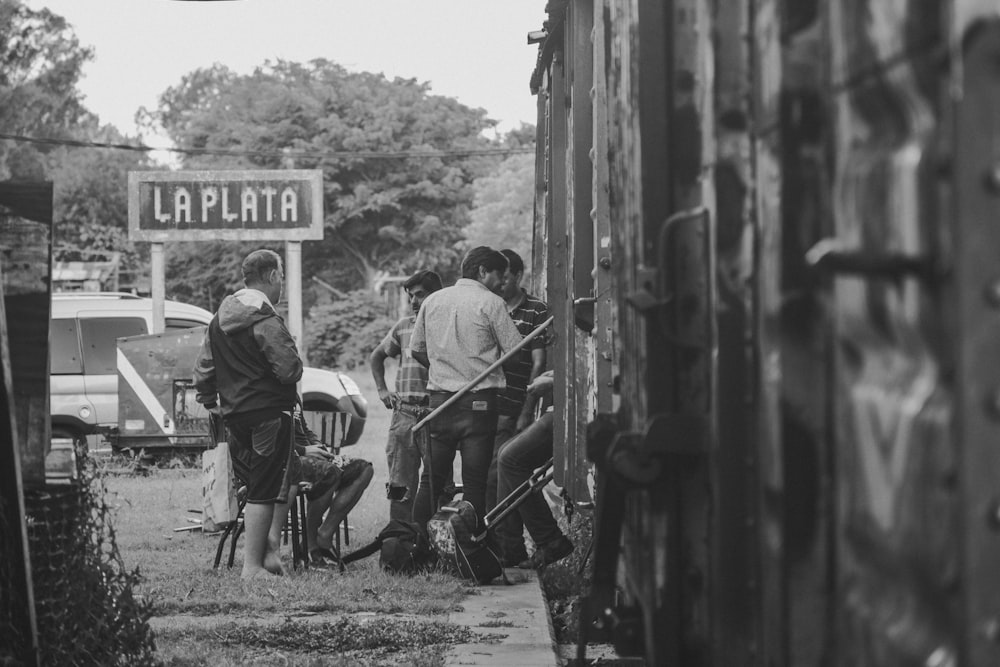 grayscale photo of people sitting on folding chairs