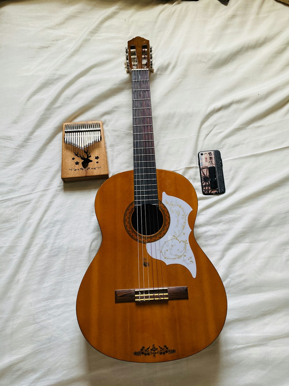 chitarra acustica marrone su tessuto bianco
