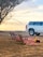 A happy family relaxing outdoors at dusk, free from mosquitoes, with a navy blue and white branded service truck in the background.