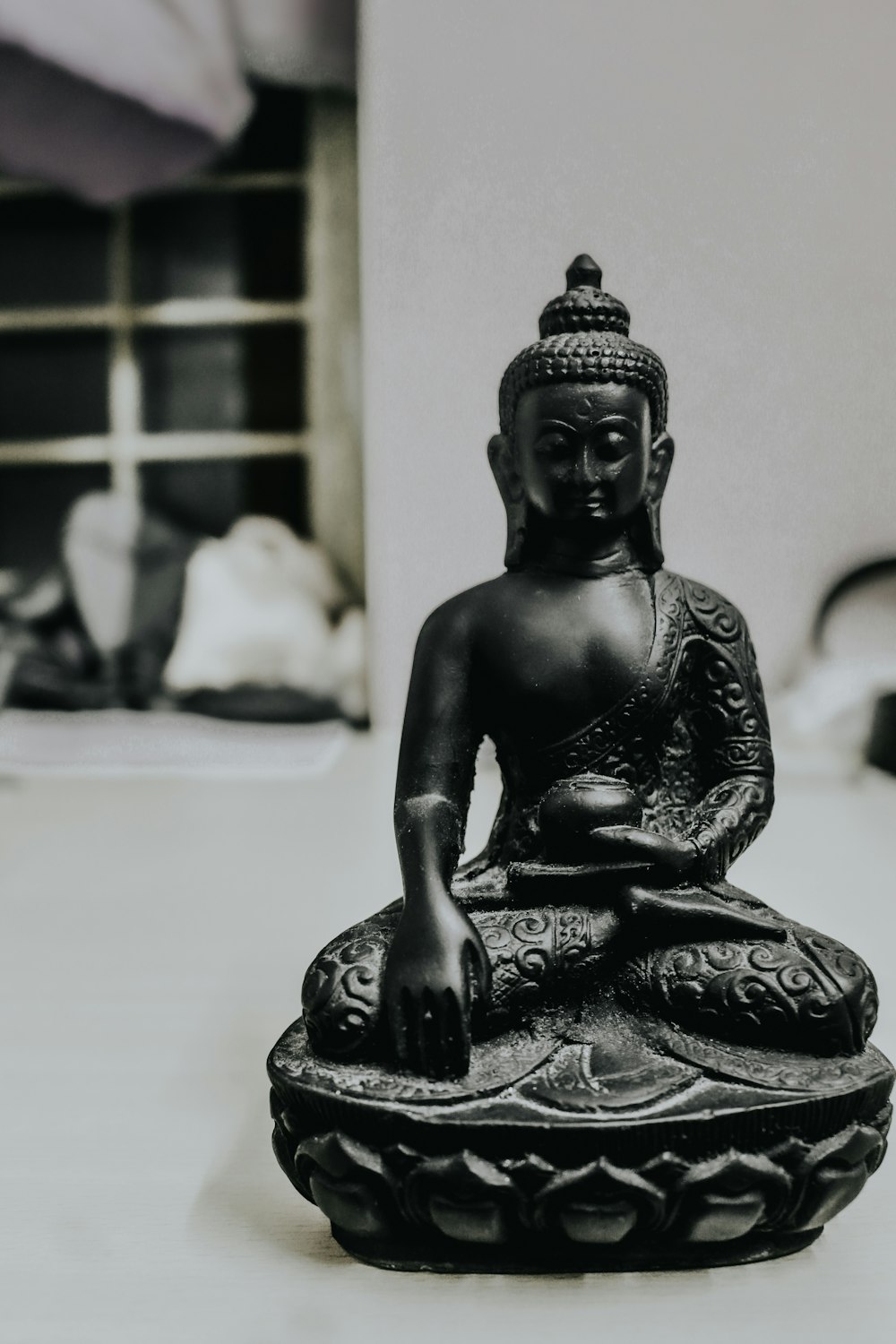 black ceramic buddha figurine on white table