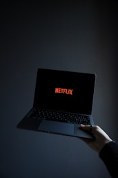 person using macbook pro on white table