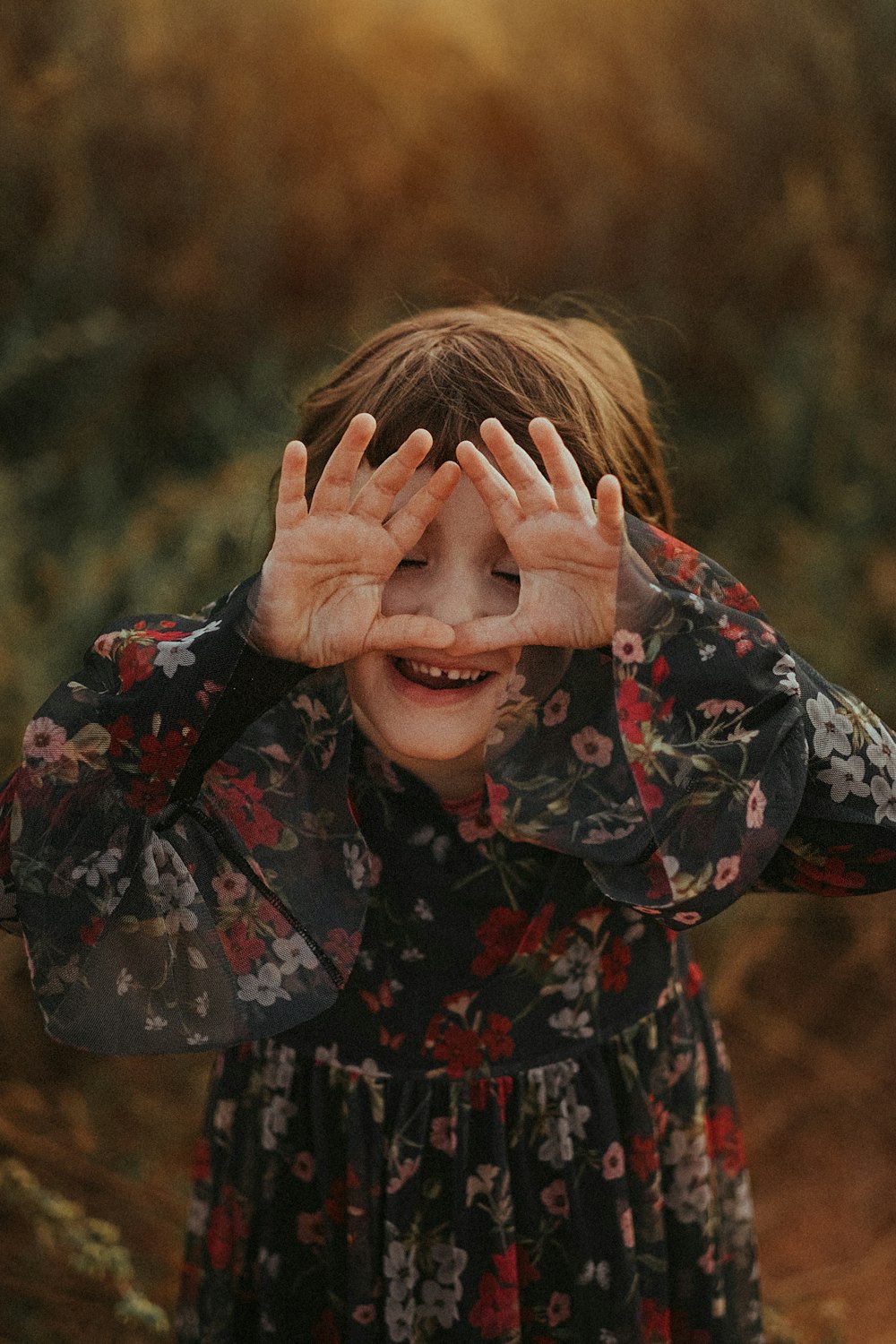 woman in black red and green floral long sleeve shirt covering her face