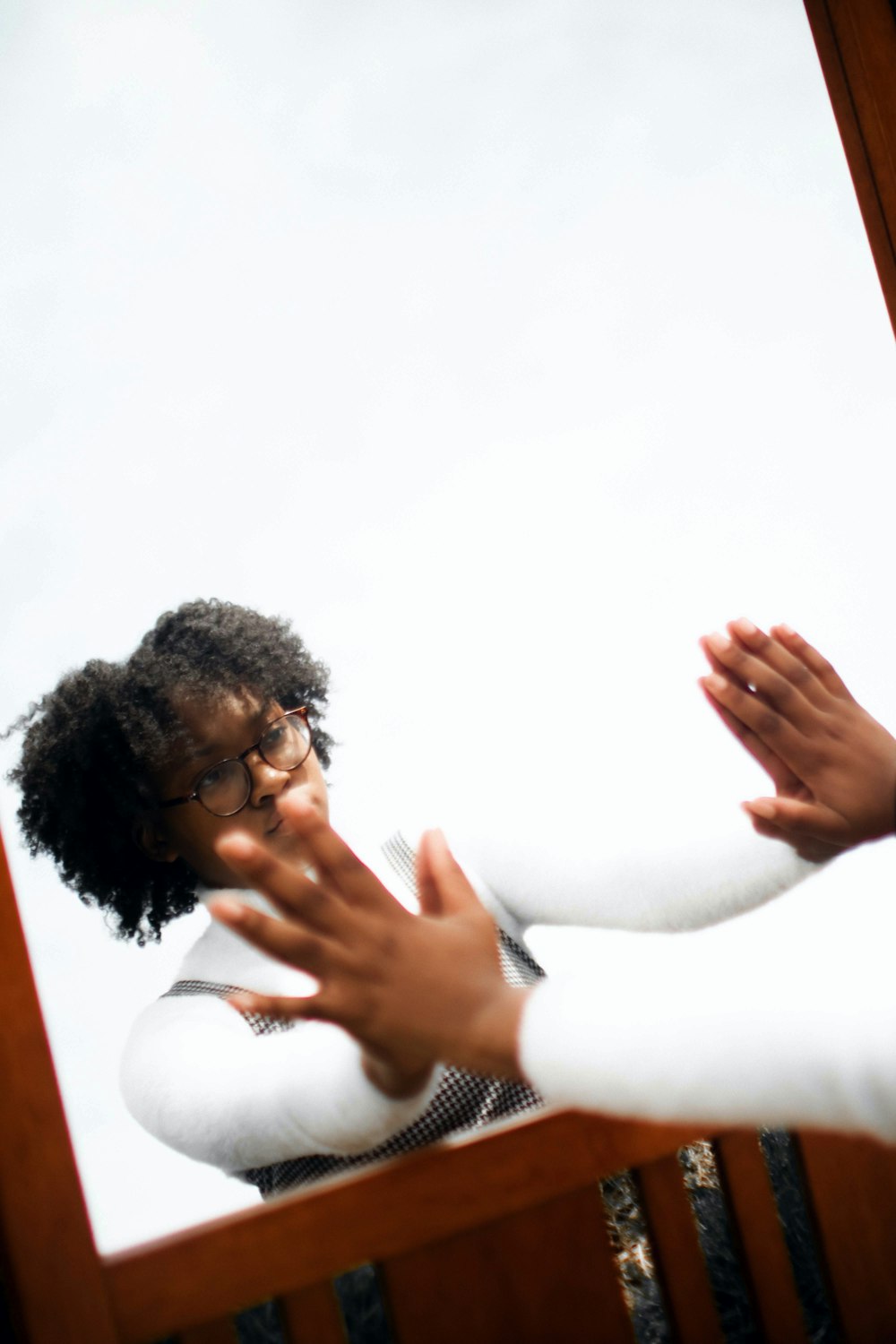 woman in white long sleeve shirt holding her face