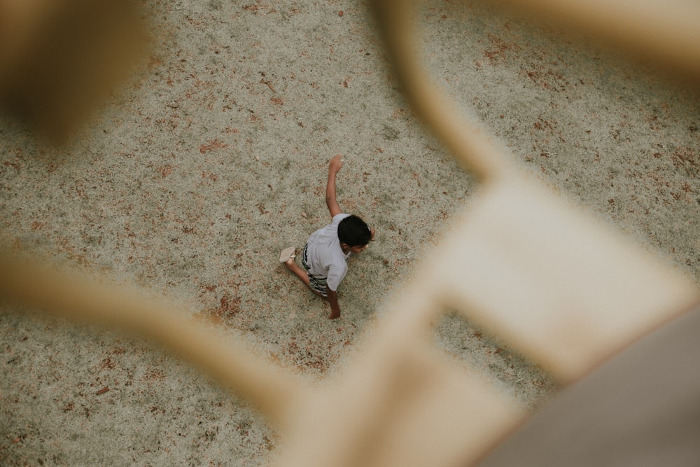 man in white shirt and gray pants walking on gray sand during daytime