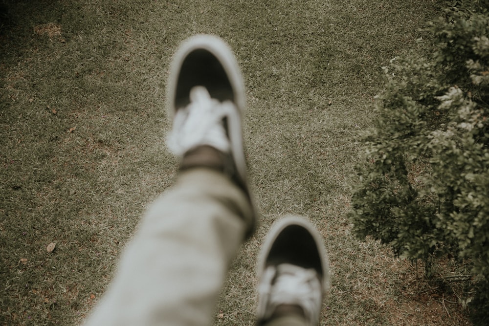 person in gray pants wearing black and white sneakers