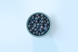 black and red berries in green ceramic bowl