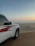 A red Fiat Panda of dexertgo navigating sandy dunes at sunset.