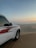 A red Fiat Panda of dexertgo navigating sandy dunes at sunset.