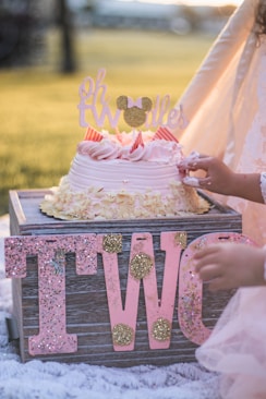 person holding white and brown floral cake