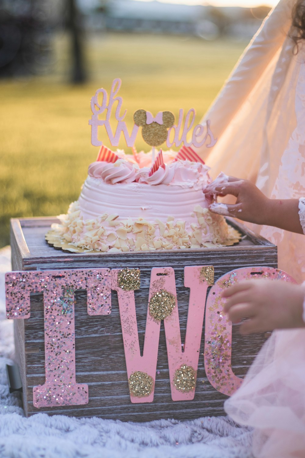 person holding white and brown floral cake