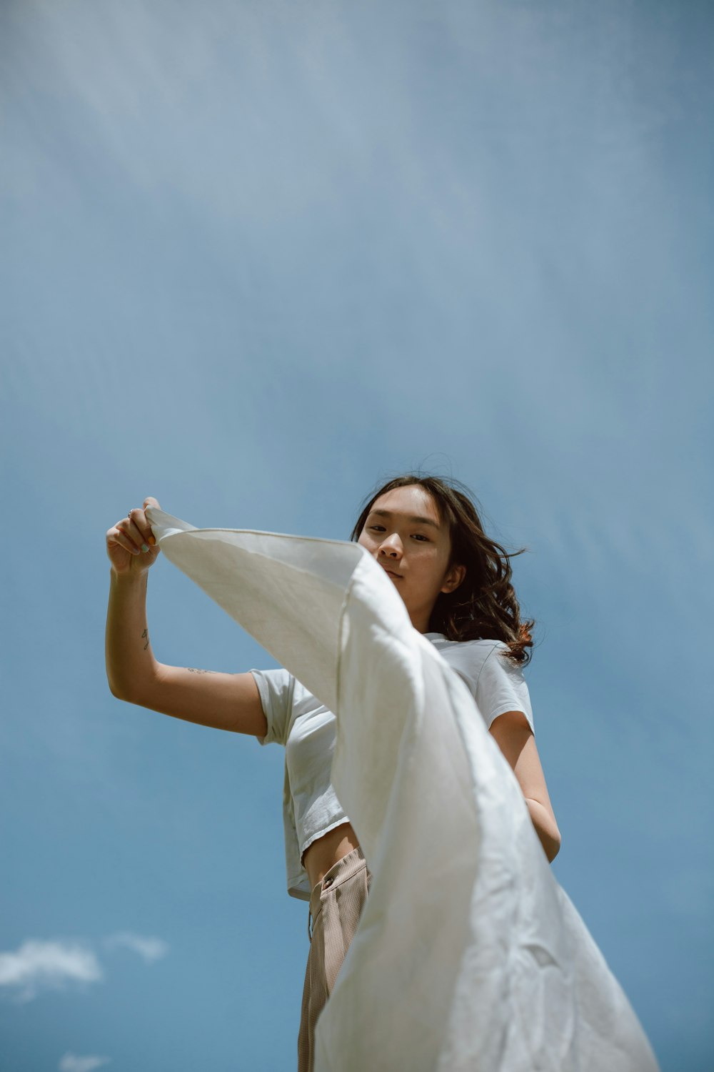 Femme en robe blanche tenant un textile blanc