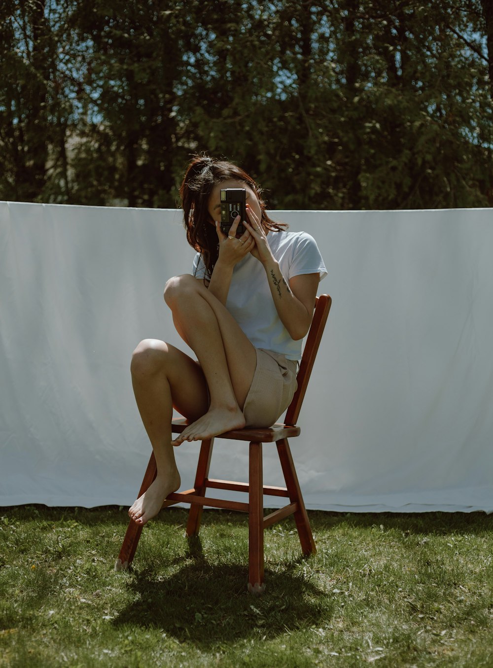 woman in white dress sitting on brown wooden chair