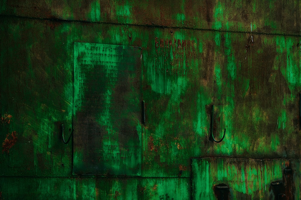 green wooden door with black metal door lever