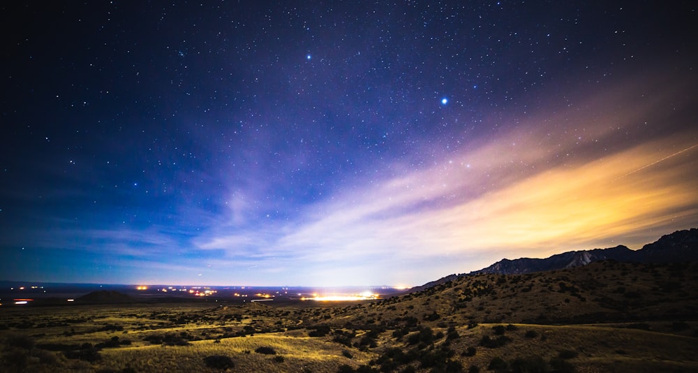 brown and green mountains under blue sky during night time