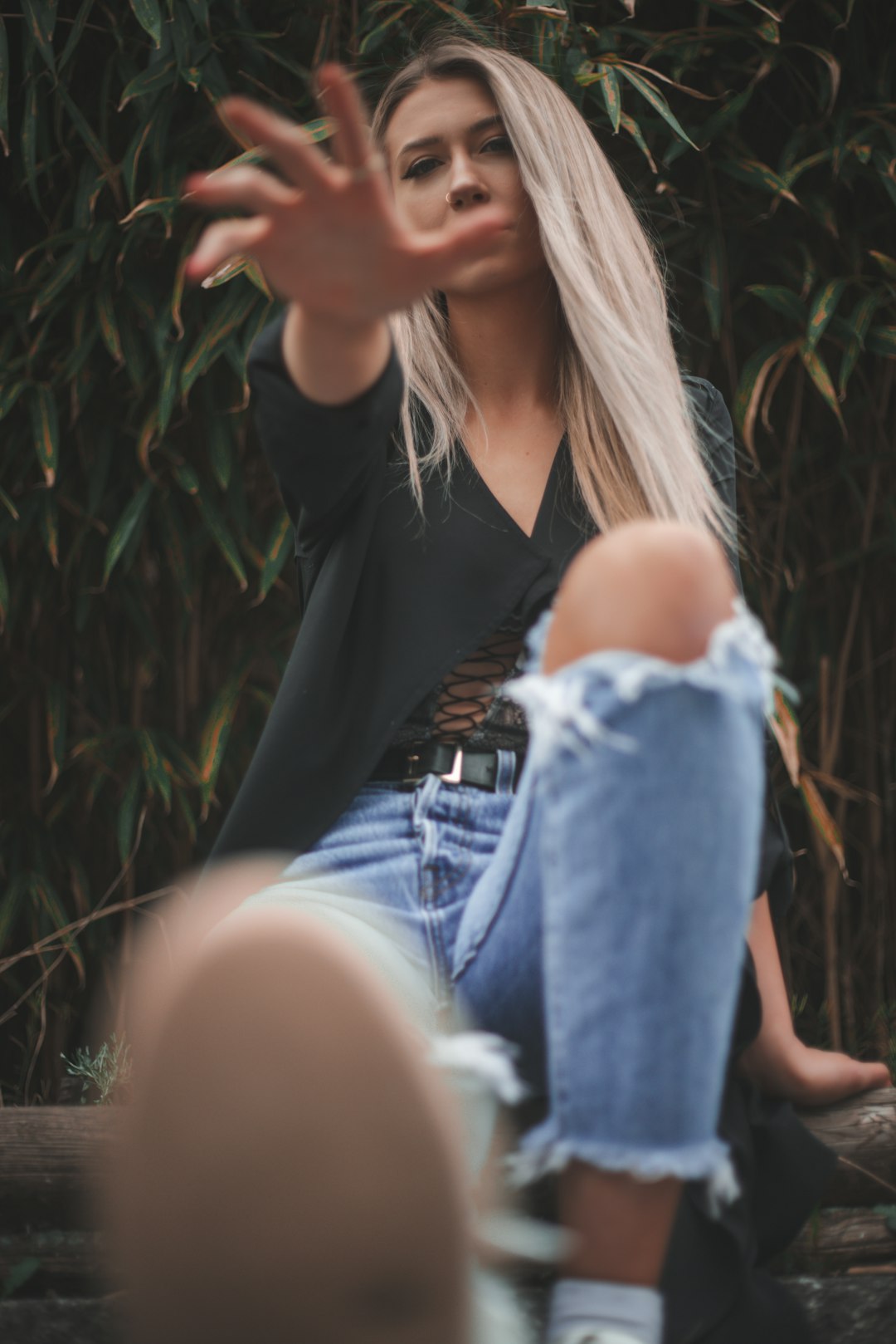woman in black tank top and blue denim jeans sitting on ground