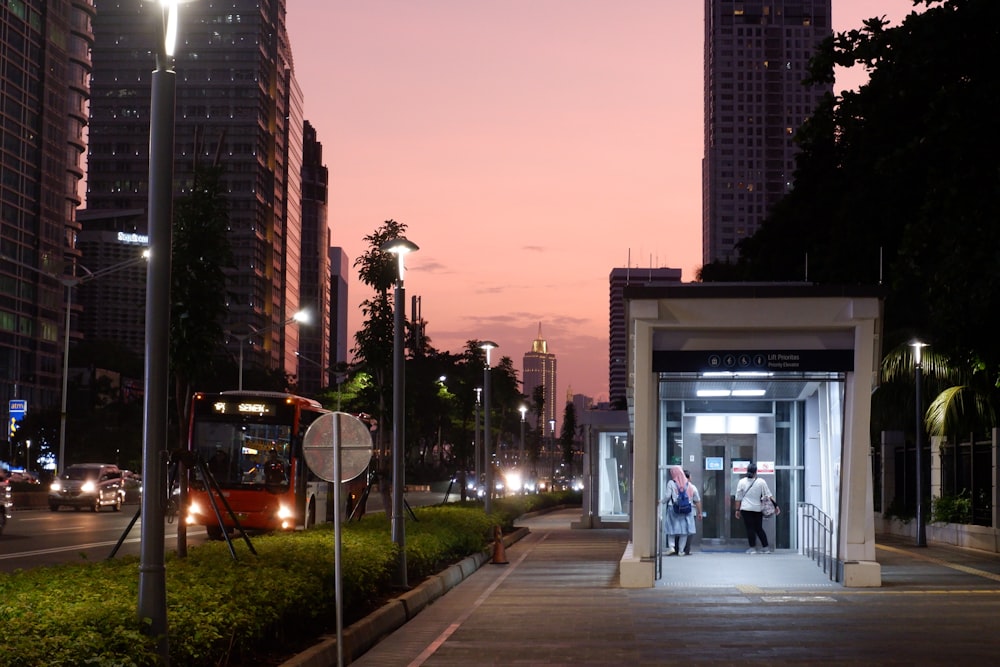 people walking on sidewalk near high rise buildings during sunset