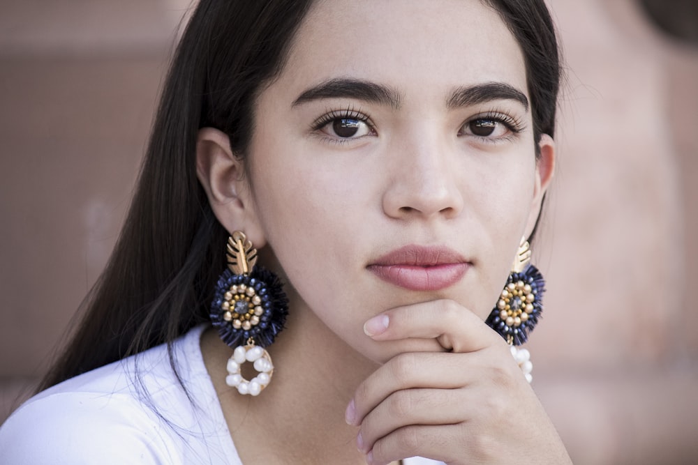 woman in white shirt wearing blue and gold beaded necklace