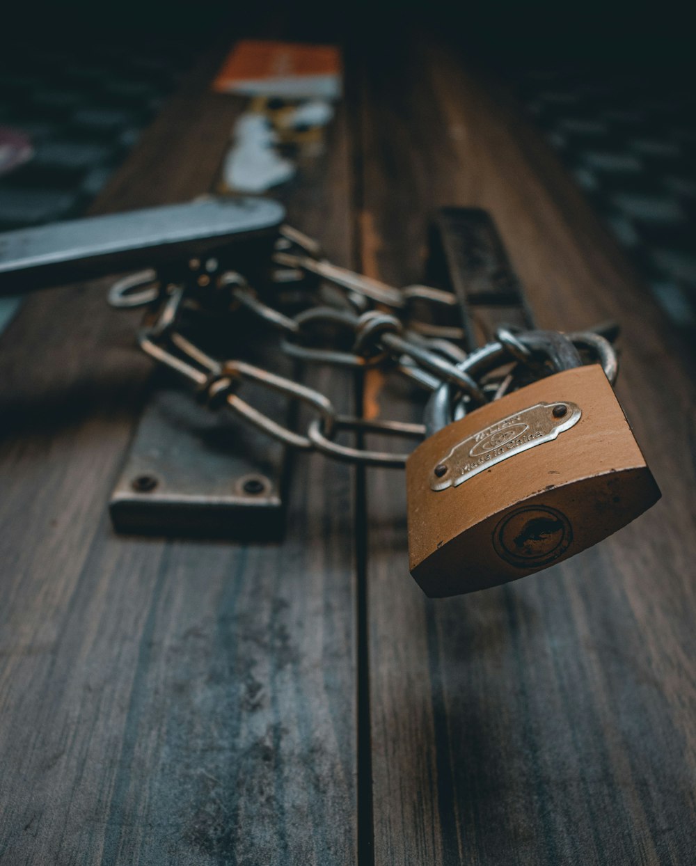 brown padlock on brown wooden surface