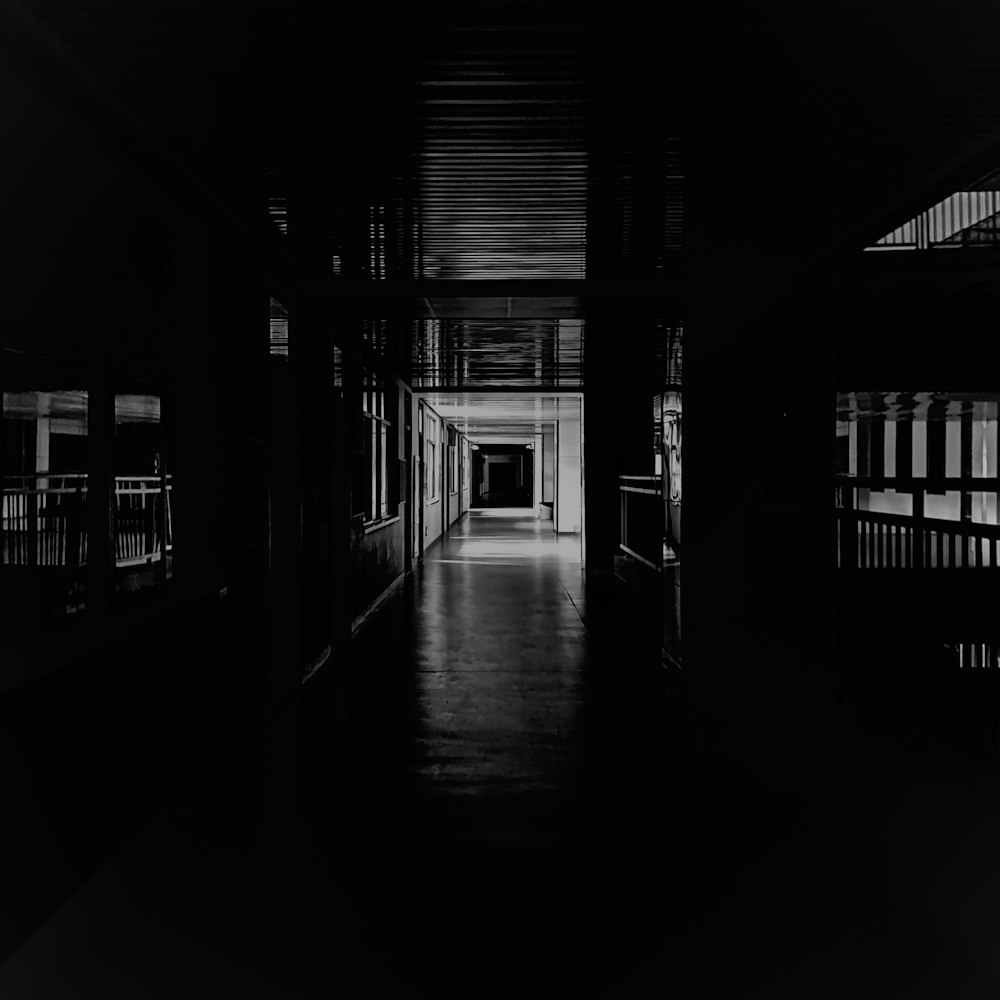 grayscale photo of hallway with glass windows