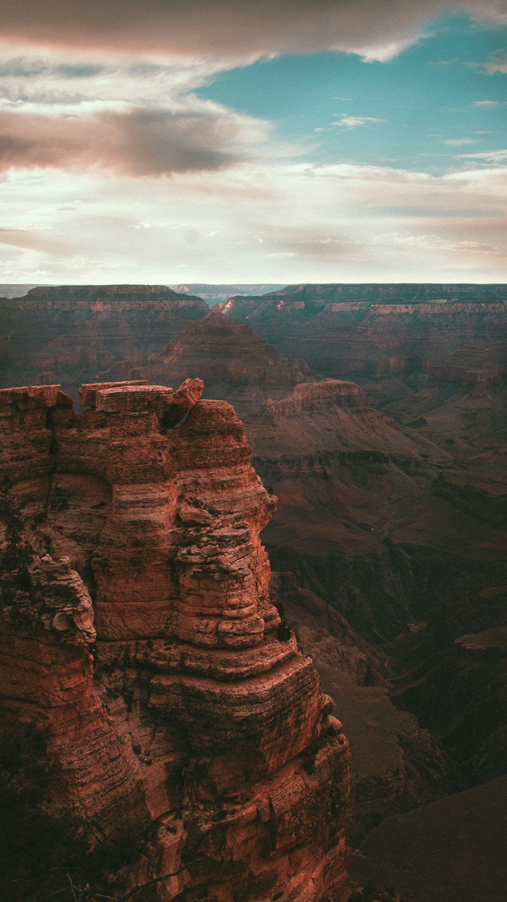 man sitting on brown rock formation during daytime