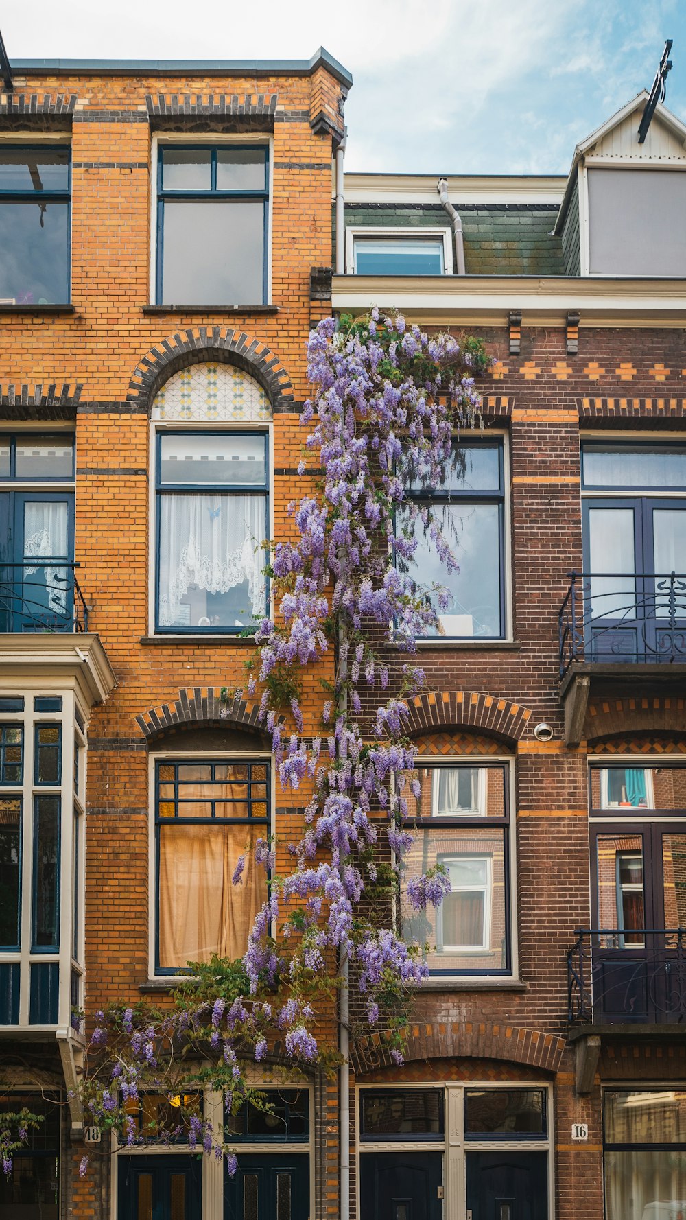 brown brick building with purple flowers