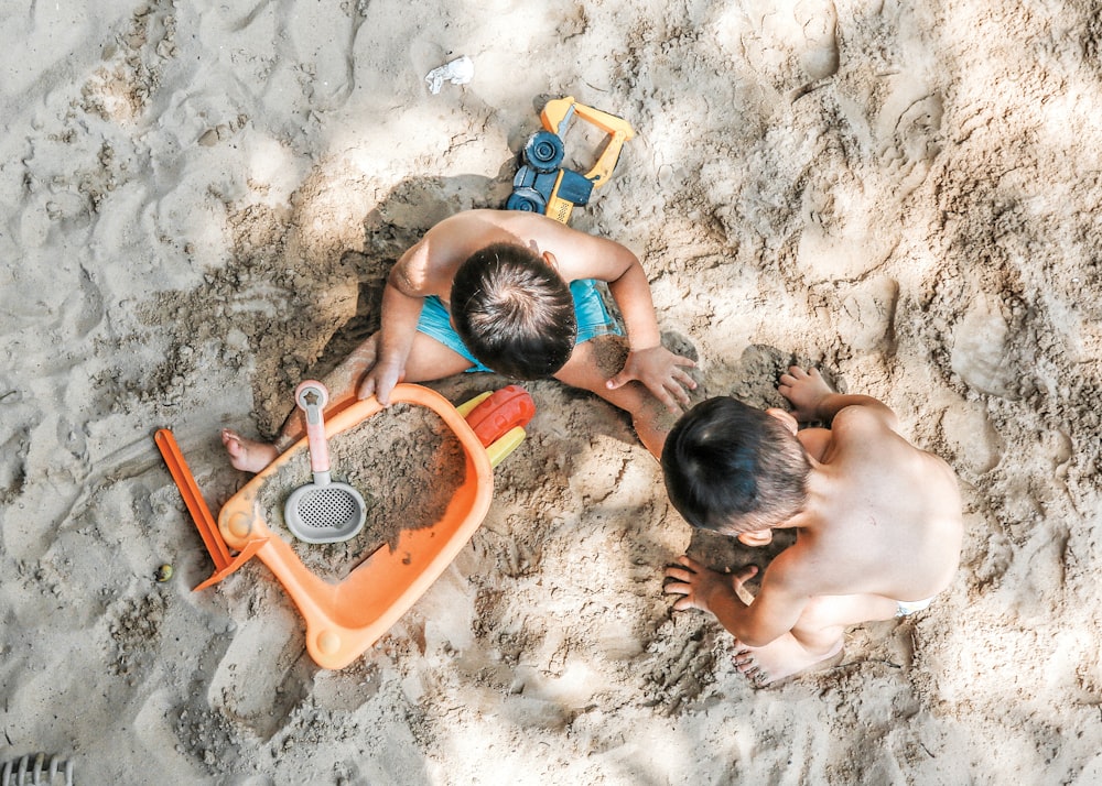 砂の上に座っている2人の男の子