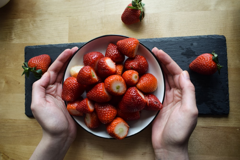 strawberries on black ceramic bowl