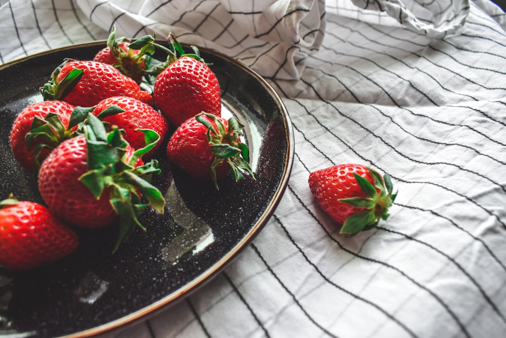 strawberries on black ceramic bowl