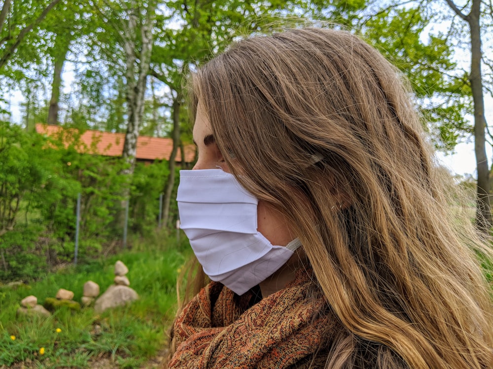 woman in brown knit sweater covering her face with white textile