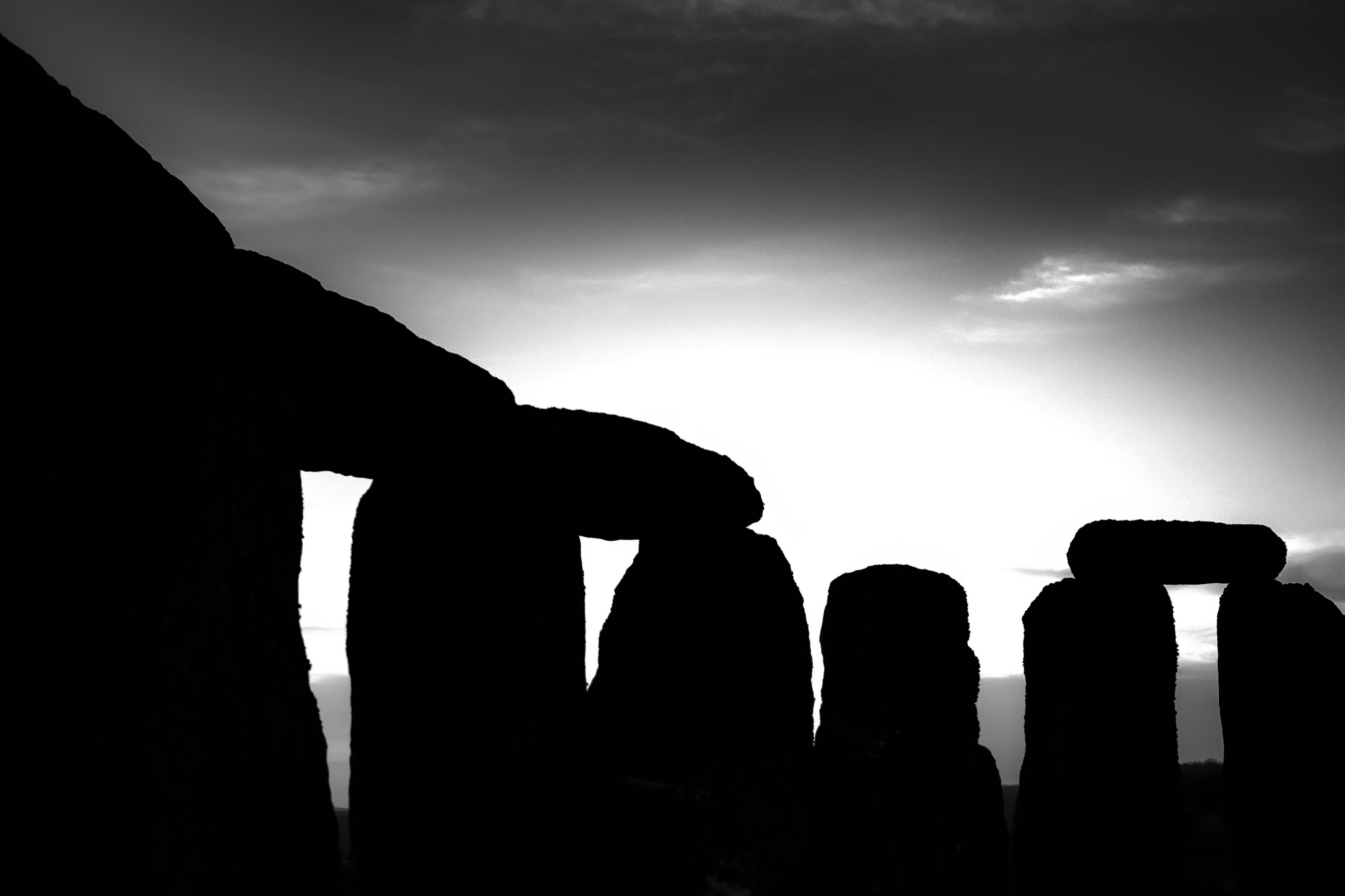 silhouette of rock formation under cloudy sky, Prehistoric ritual site of Stonehenge with monliths - large stone slabs in rural England, UK. February 2020. Sunrise time.