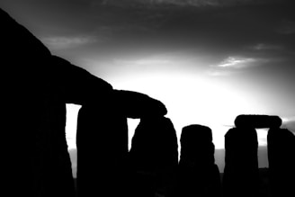 silhouette of rock formation under cloudy sky