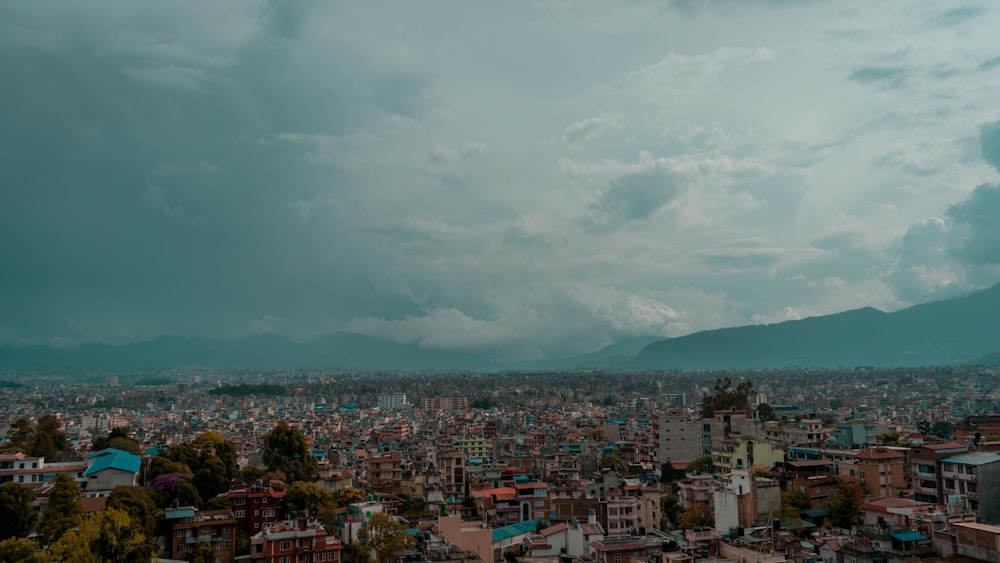 city with high rise buildings under white clouds during daytime