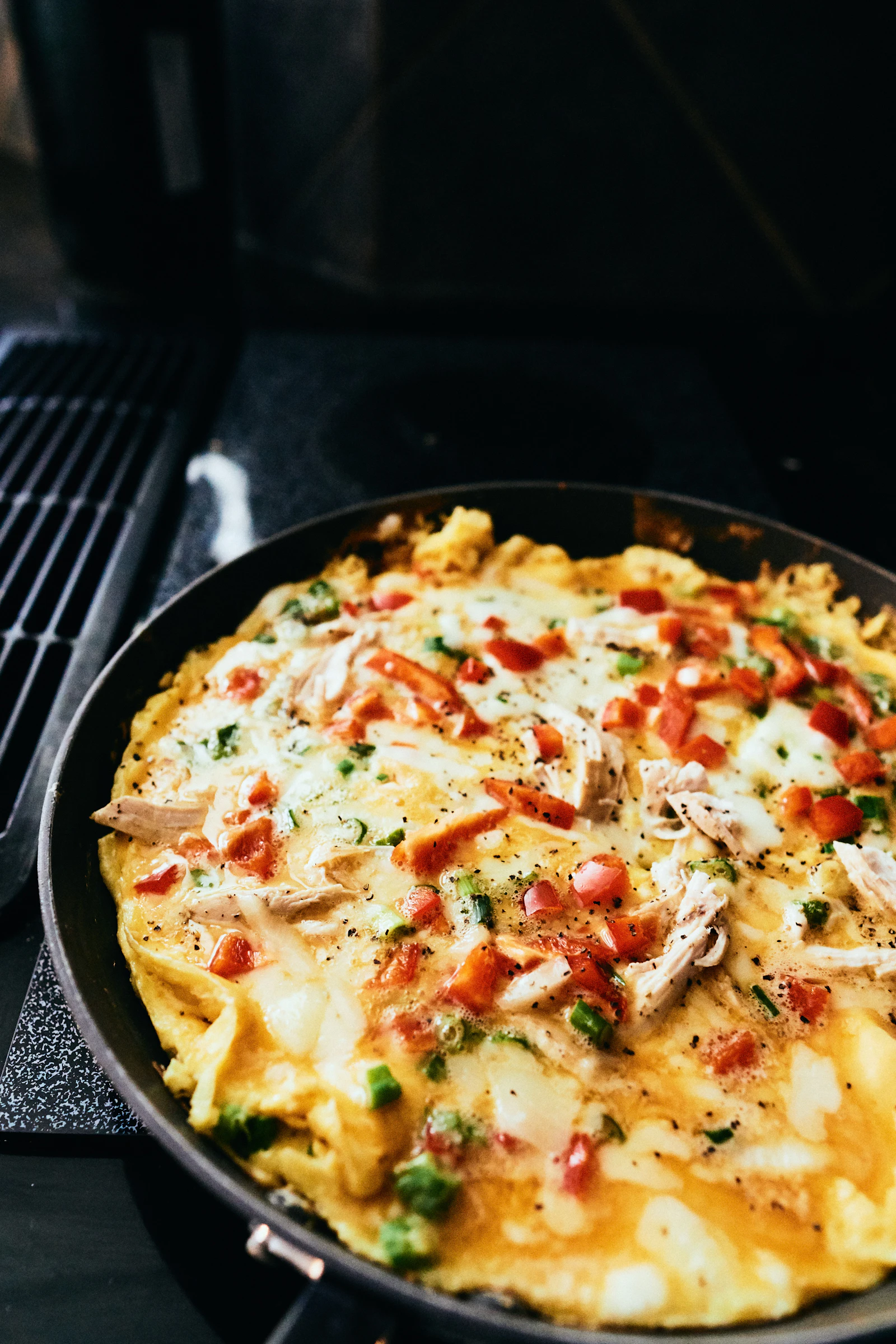 Omelette dorée garnie de légumes et de fromage dans une poêle