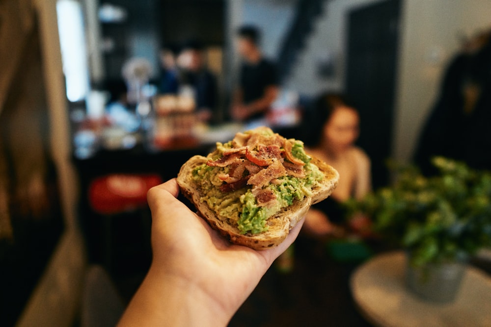 緑と茶色の食べ物を持っている人