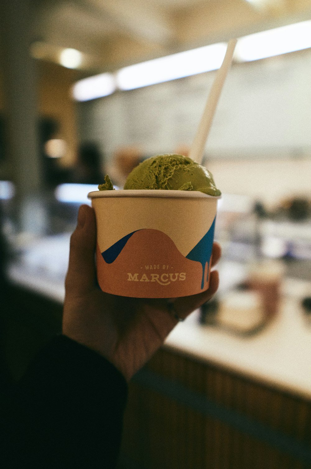 person holding green and white ice cream cup