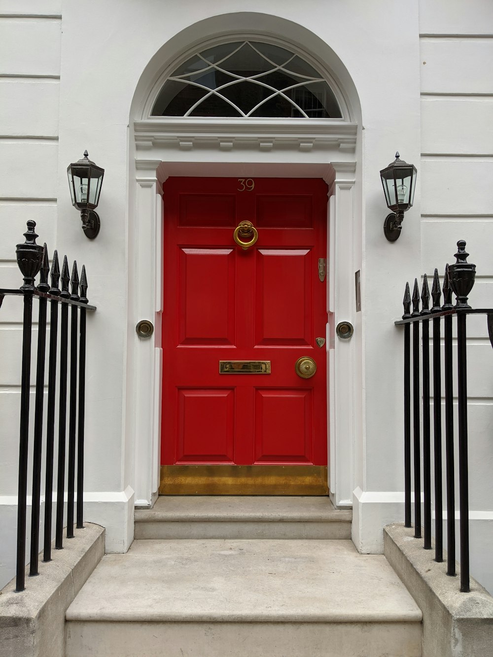 red wooden door with black metal gate