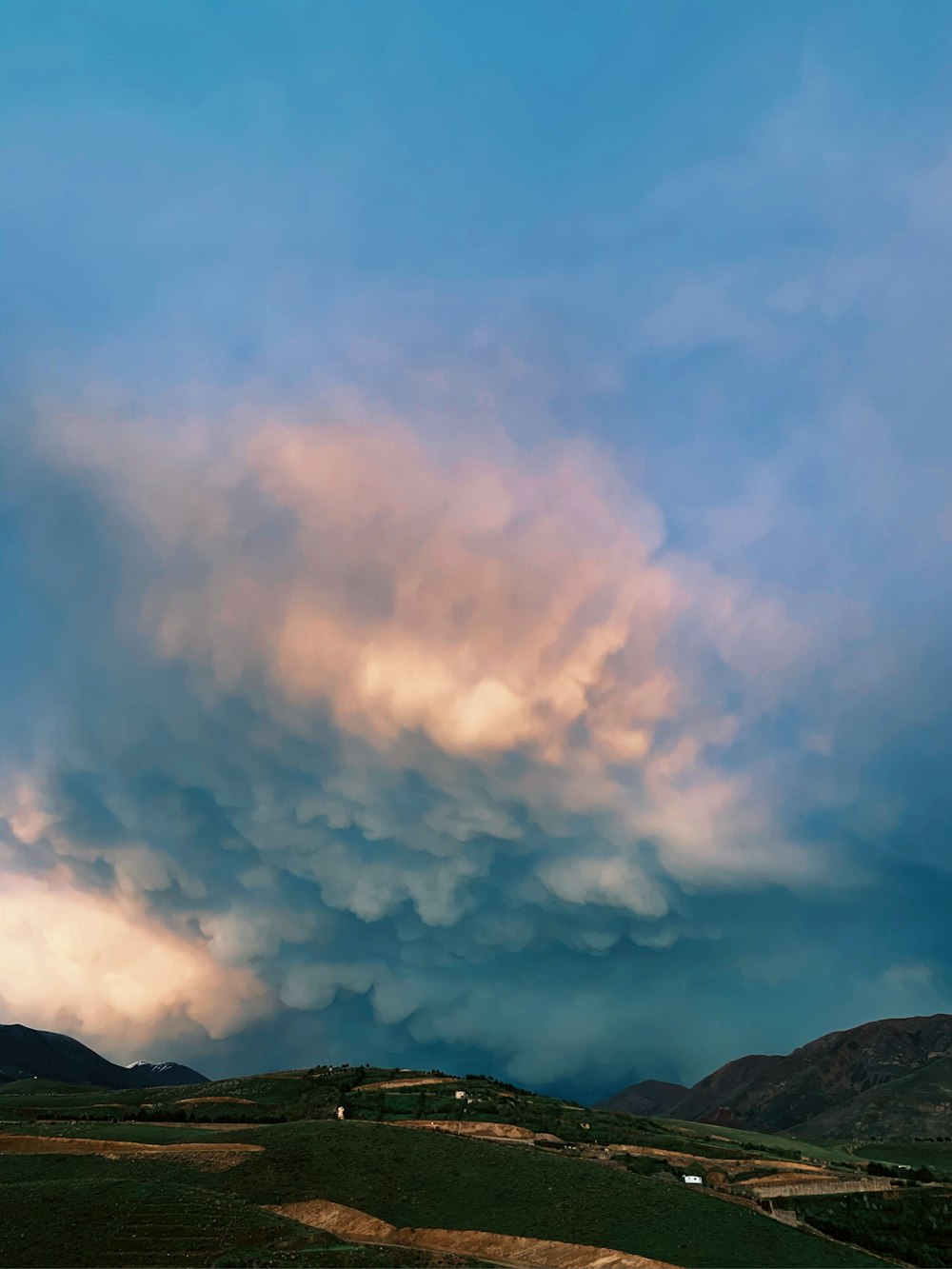 white clouds over green mountains during daytime