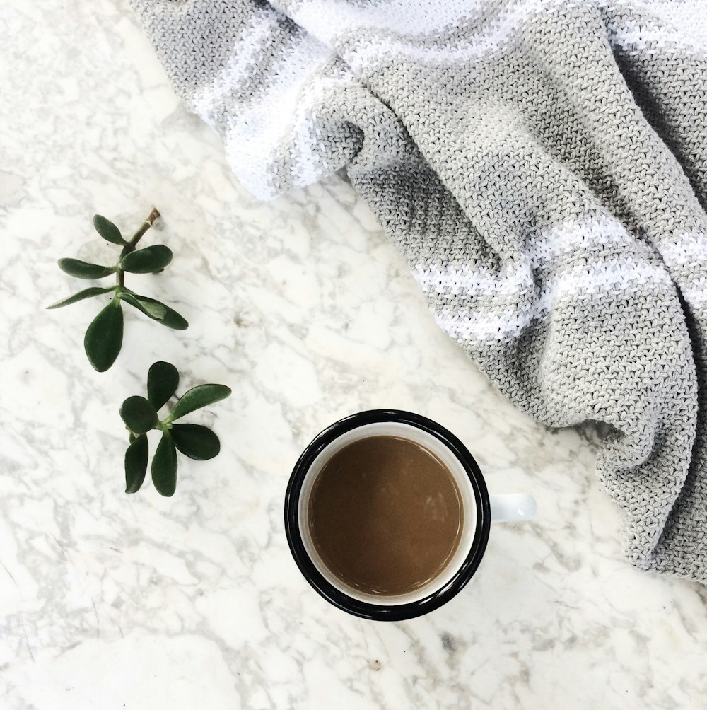 white ceramic mug with brown liquid