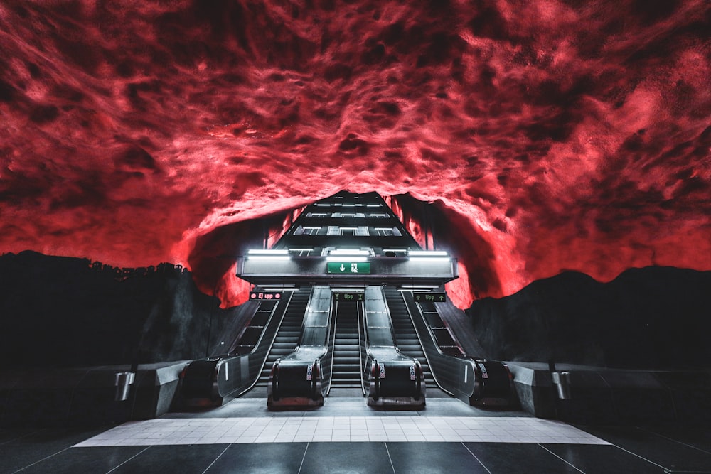black and white escalator under red sky