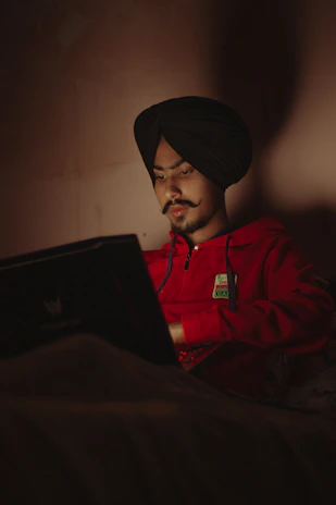 Portrait of Muhammad Zulqurnain working on a laptop in a cozy home office.
