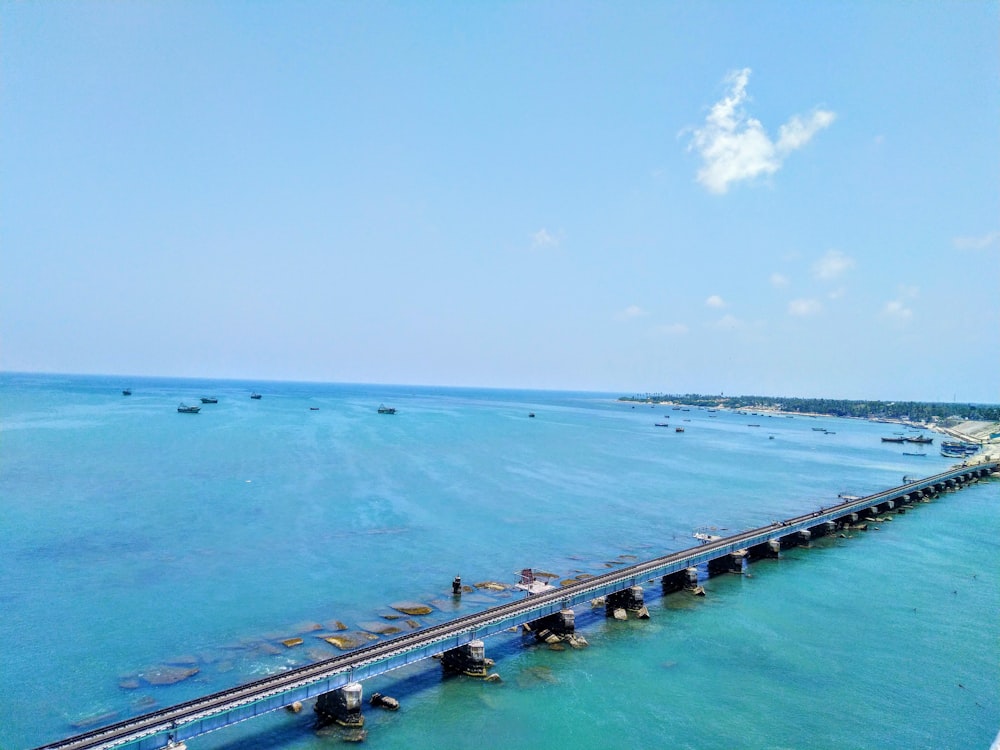 brown wooden dock on sea under blue sky during daytime