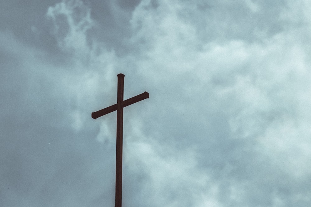 brown wooden cross under cloudy sky during daytime