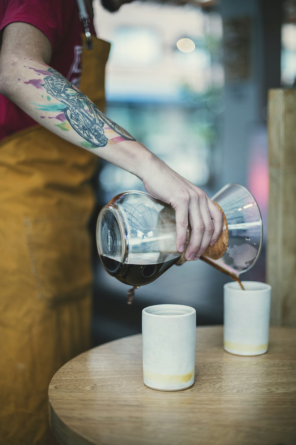 person pouring water on clear glass cup