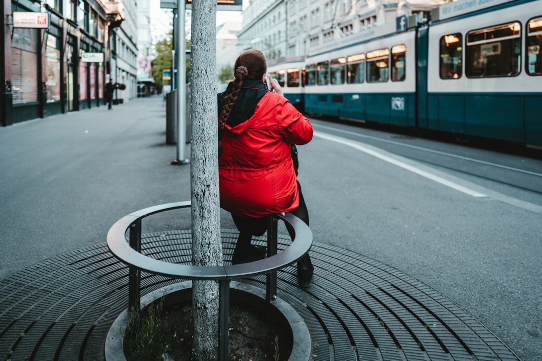 woman in red jacket sitting on gray round table