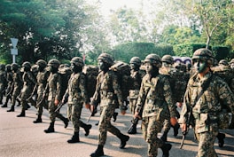 group of men in camouflage uniform standing on road during daytime