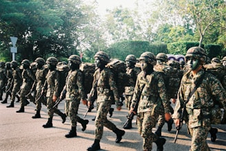 group of men in camouflage uniform standing on road during daytime